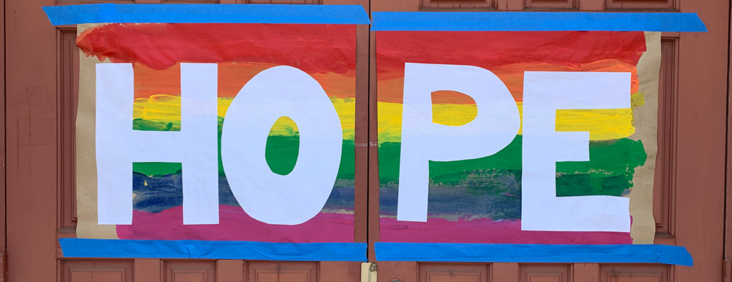 Hand-painted sign on church doors, reading "Hope"