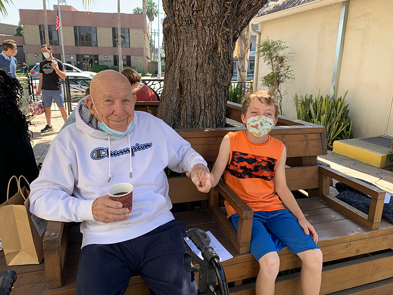 Elder gentleman and boy at outdoor social hour